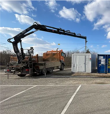LKW mit Heckkran hebt Container